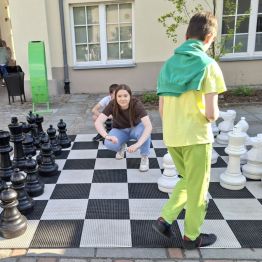 Wychowankowie na dziedzińcu muzeum grają w szachy.