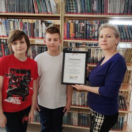 Uczniowie klas I-III wręczający podziękowania za udział w zajęciach bibliotecznych