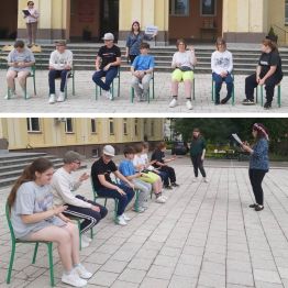 Wychowankowie siedzą na krzesłach, uczestniczą w zabawie pt. "Wyścigi konne".