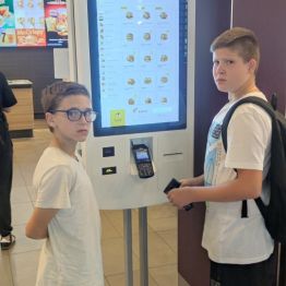 Dwóch chłopców stoi przy monitorze da zamówień