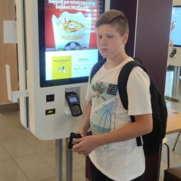 Chłopiec stoi przy ekranie do zamówień