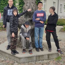 Pięciu chłopców stoi przy pomniku 