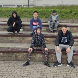 Pięciu chłopców siedzi na murku