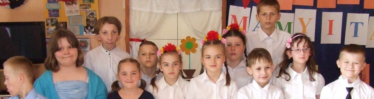 Dziewczynki w białych bluzkach z wiankami na głowach.