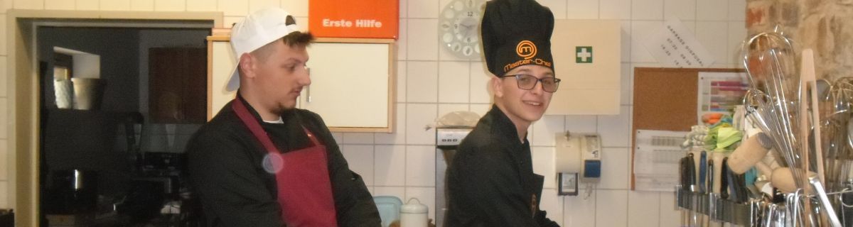 Nastoletni chłopcy w fartuchach w kuchni.