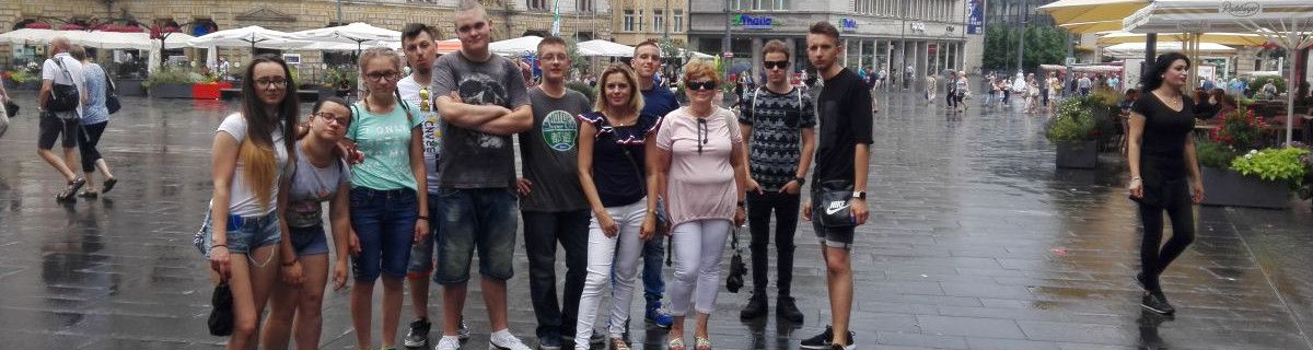 Grupa nastoletnich uczniów na miejskim rynku.