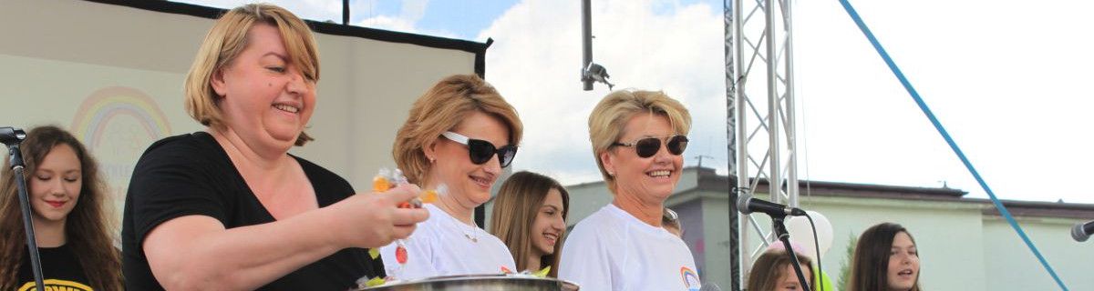 Panie dyrektor na scenie, jedna trzyma cukierki 