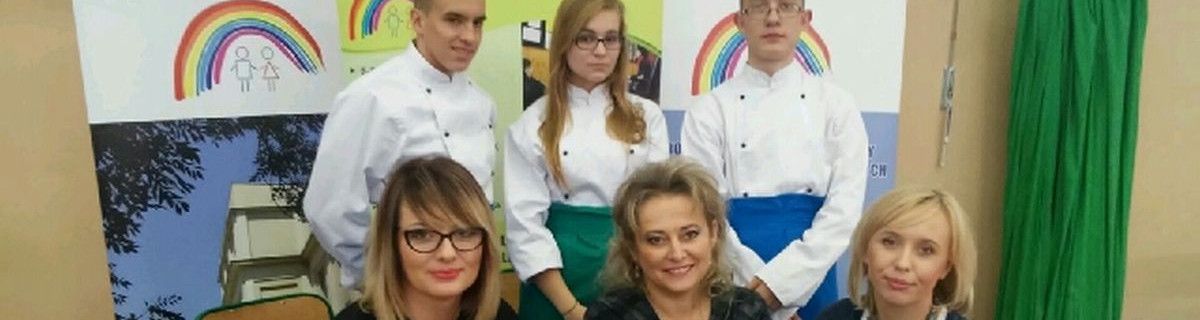 Uczniowie w fartuchach kucharskich, obok trzy nauczycielki