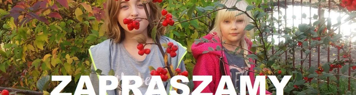 Dwie dziewczynki stoją przy krzewach, a przed nimi biały napis "Zapraszamy"
