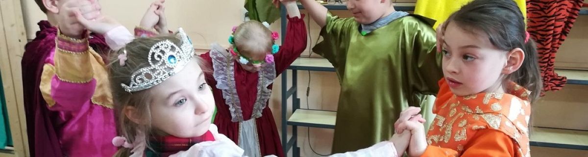 Uczniowie przebrani za baśniowych bohaterów tańczą w kole