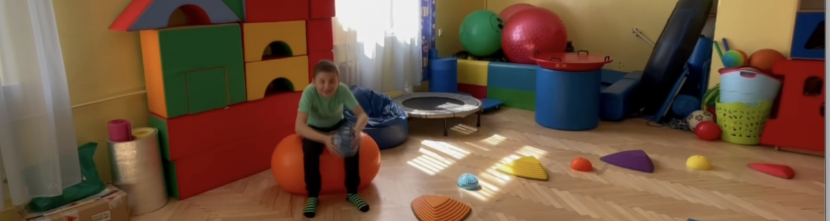 Uczeń podrzuca piłkę w sali do integracji sensorycznej