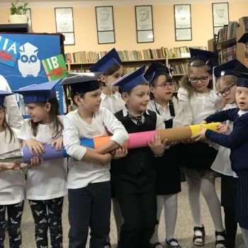 Uczniowie klas pierwszych trzymają symbol pasowania na ucznia pierwszej klasy. 