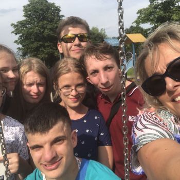 Klasa II a BS razem z panią na placu zabaw. Dominika trzyma podręcznik do języka polskiego "To się czyta".