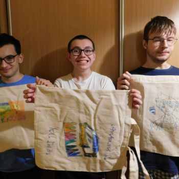 chłopcy trzymają przed płócienne torby z własnoręcznie wykonanymi wzorami