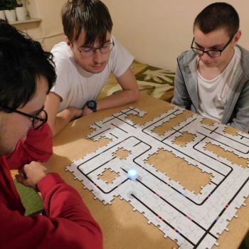 chłopcy ucza sie programowania za pomocą puzli i ozobota
