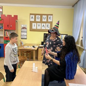 Uczeń klasy I e stoi przy stoliku z wróżbami.