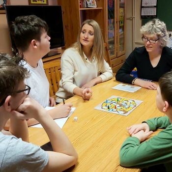 Pani Kasia  i Pani Edyta wieczorem grają wspólnie z wychowankami w grę planszową.