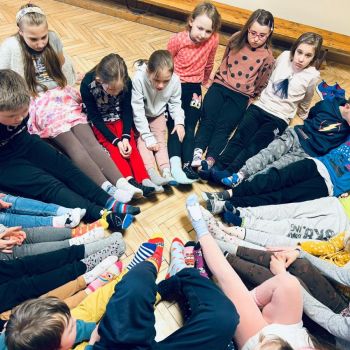 dzieci z klas I-III we wspólnym kręgu w kolorowych skarpetkach