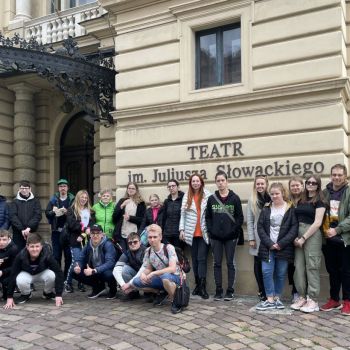 Uczestnicy wycieczki przed budynkiem teatru. Za nimi widnieje napis: TEATR im. Juliusza Słowackiego.