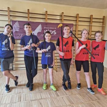 dzieci pozują w sali gimnastycznej na tle plakatu