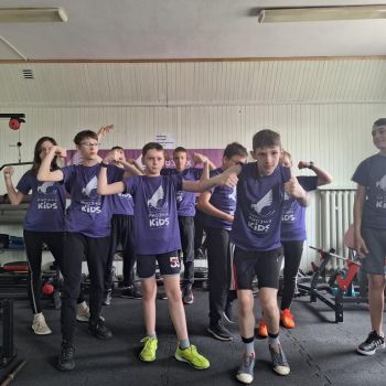 dzieci prezentują swoje bicepsy