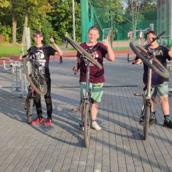 Chłopcy stoją przy rowerach.