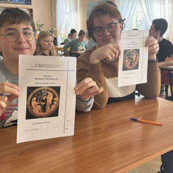 Uczniowie trzymający arkusze konkursowe
