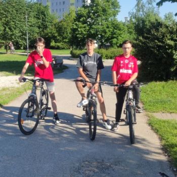 Trzech chłopców stoi przy rowerach