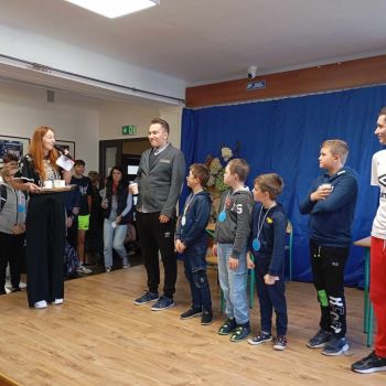 Dzieci stoją na scenie śpiewają piosenkę.