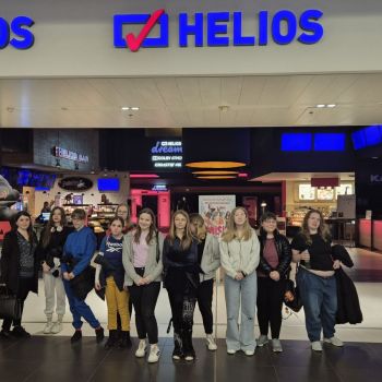 Wychowankowie pozują do zdjęcia przed wejściem do kina „Helios”.