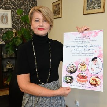 Pani Dyrektor ZPSW - Marta Jagniątkowska trzyma w rękach plakat "Wiosenne Warsztaty Kulinarne z Kurtem Schellerem"