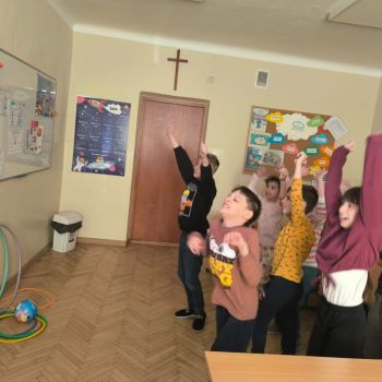 Uczniowie klasy 1b i 2 a Szkoły Podstawowej podczas zajęć przygotowujących do utrwalania orientacji przestrzennej z elementami muzykoterapii