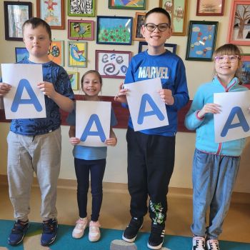 Dzieci w niebieskich strojach z literą A - solidarni dla autyzmu