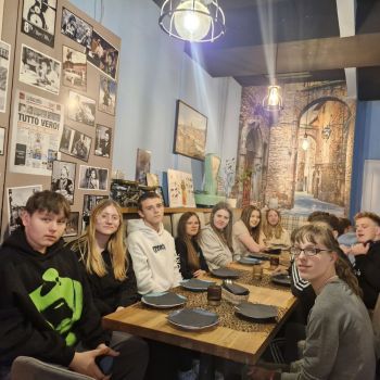 Wychowankowie wspólnie pozują do zdjęcia w pizzerii