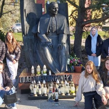 Wychowankowie stoją przy pomniku św.Jana Pawła II