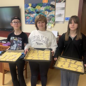 Dziewczynki prezentują ciasteczka, które za chwilę będą wkładane do piekarnika. 