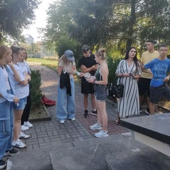 Wychowankowie zapalają znicz przy pomniku poległych żołnierzy podczas II wojny światowej.
