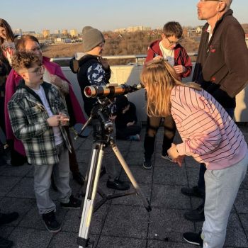 dziewczynka obserwuje niebo przez teleskop