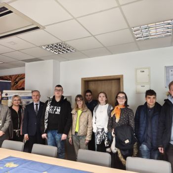 Uczniowie pozują do zdjęcia z opiekunami i przedstawicielami Banku.