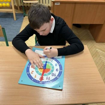 Uczeń klasy 1b zapisuje odczytaną godzinę.