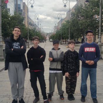 Pięciu chłopców stoi na deptaku