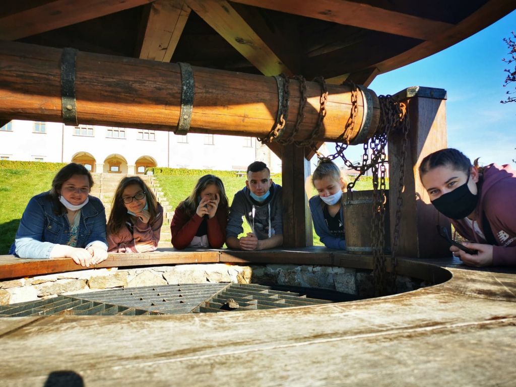 Grupa uczniów przy zabytkowej studni
