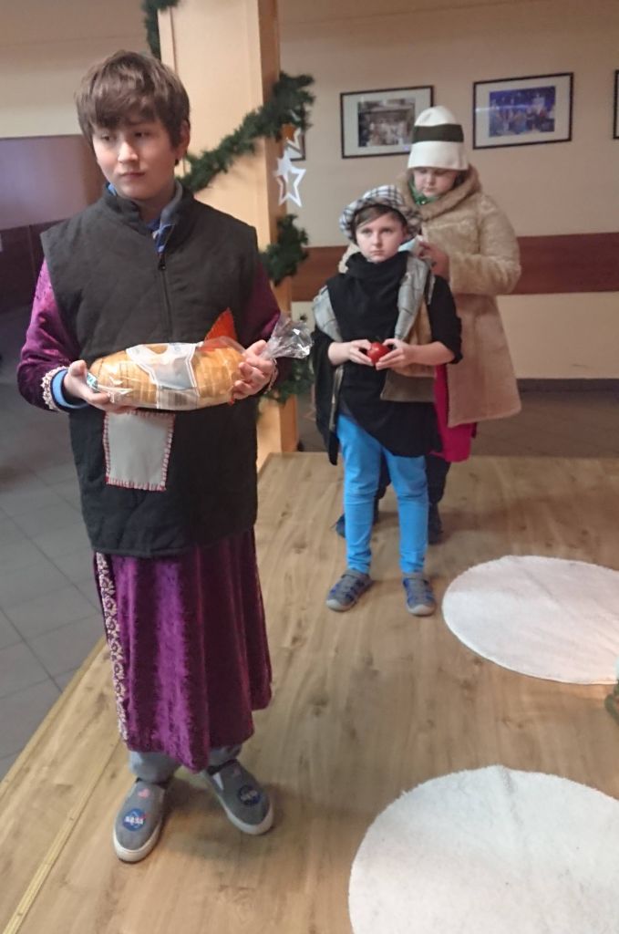 Jasełka - chłopcy w ciepłych ubraniach niosą chleb, owoce