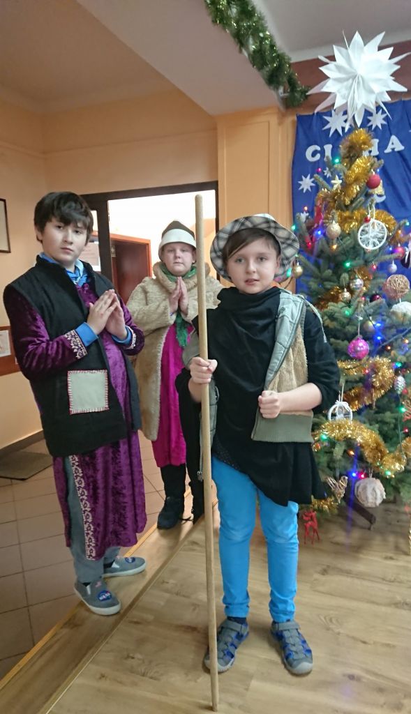 Jasełka - chłopcy w ciepłych ubraniach modlą się